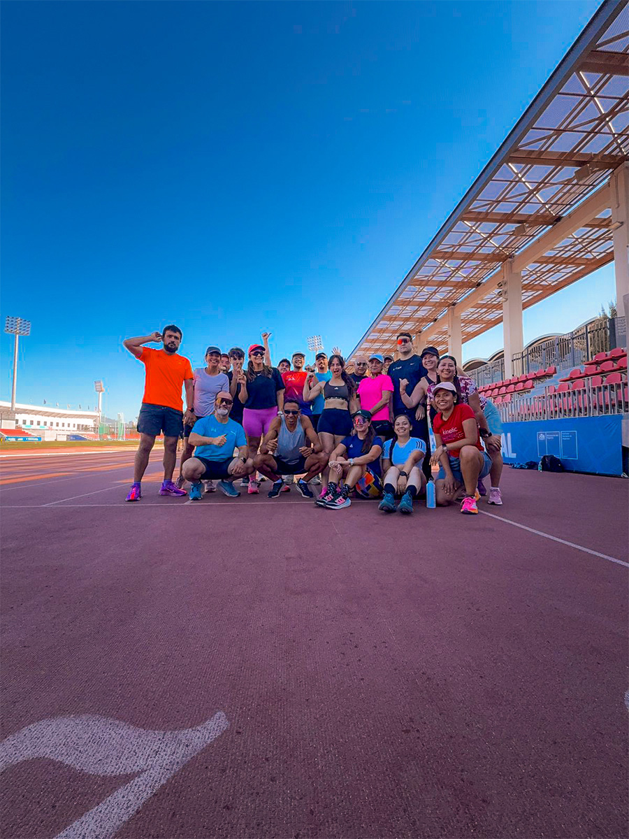 Integrantes de Ñuñoa Runners posan juntos sobre una pista atlética
